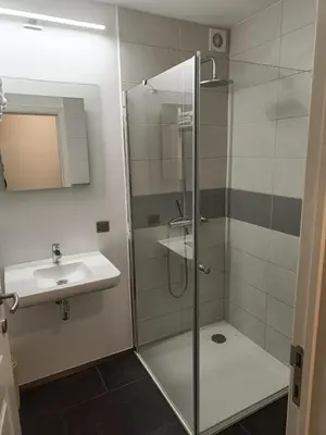 a bathroom with a glass shower and a sink at Nimary Logies in Heusden - Zolder
