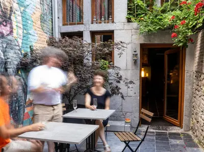 a group of people sitting at tables outside a building at Bonjour Pierreuse in Liège
