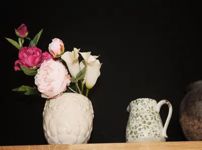 a white vase with flowers sitting on a shelf at Bonjour Pierreuse in Liège