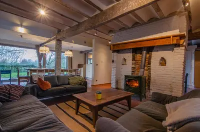 a living room with couches and a fireplace at Vakantiewoning De Luysmolen in Bocholt