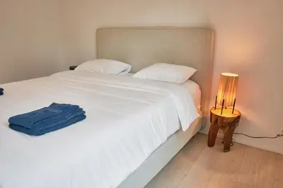 a bedroom with a white bed with a blue towel on it at Urbanchic Appart lumineux hyper centre in Liège