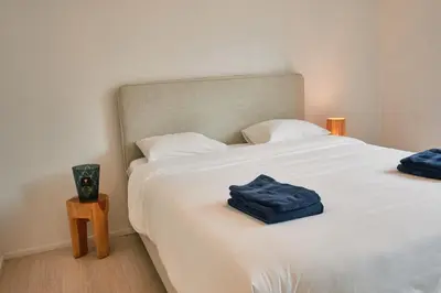 a bedroom with a white bed with blue towels on it at Urbanchic Appart lumineux hyper centre in Liège