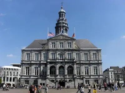 a large building with a tower on top of it at Duplex Apartment in the shopping street of Maasmechelen in Maasmechelen