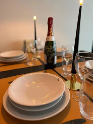 a table with plates and glasses and a bottle of wine at Red cross street in Lommel