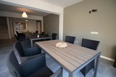 a dining room with a wooden table and chairs at De Hoog Velden 15 in Overpelt