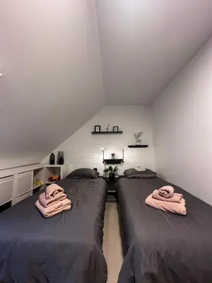 two beds in a attic room with towels on them at Bos-Chalet bij Wijers Wandelroutes, Rust & Gezinsplezier Fijnspar 108 Hengelhoef in Houthalen-Helchteren