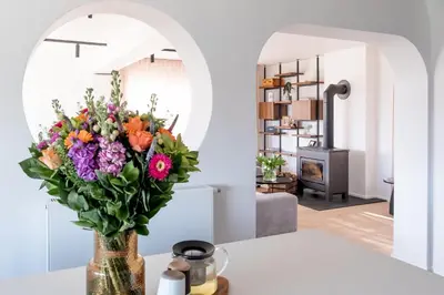a vase of flowers on a table in a living room at MAM Haspengouw in Sint-Truiden