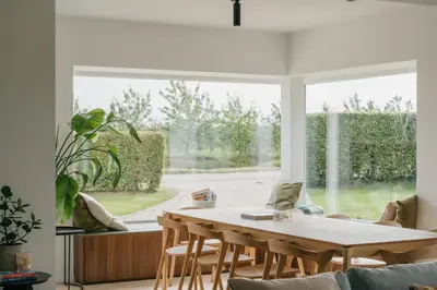 a living room with a table and a large window at MAM Haspengouw in Sint-Truiden