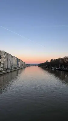 a river with buildings in the middle of a city at Studio Montaigne in Liège
