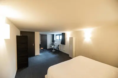 a hotel room with a bed and a desk at Smart Bnb - Appart Hotel Battice in Herve
