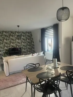 a living room with a bed and tables and chairs at Le cocon de la belle liégeoise in Liège