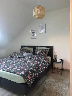 a bedroom with a bed with a comforter and a table at Le cocon de la belle liégeoise in Liège