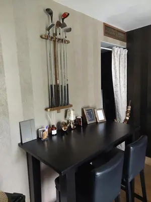 a black dining room table with two chairs and baseball bats at La chambre et le studio du château du golf de Bernalmont in Liège