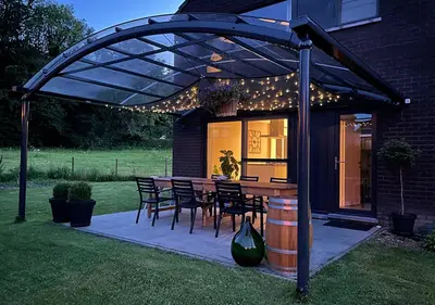 a patio with a table and chairs under a pergola at Arcaden loft in Sint-Martens-Voeren