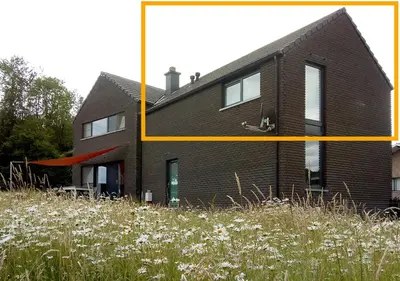 a house with a yellow line next to a field of flowers at Arcaden loft in Sint-Martens-Voeren