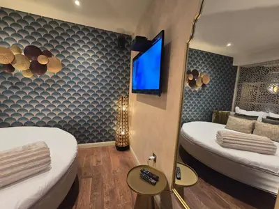a hotel room with two beds and a flat screen tv at Le Clos des Thermes in Chaudfontaine