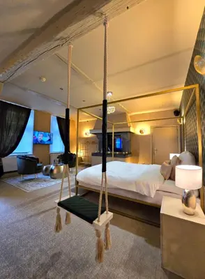 a bedroom with a large bed with a swing at Le Clos des Thermes in Chaudfontaine