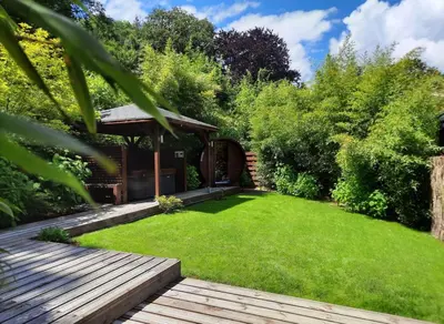 a garden with a wooden deck and a gazebo at Le Clos des Thermes in Chaudfontaine