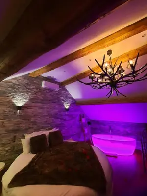 a bedroom with a bed and a purple lighting at Le Clos des Thermes in Chaudfontaine