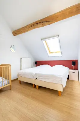 a bedroom with a bed and a skylight at Domein Tombos in Gingelom