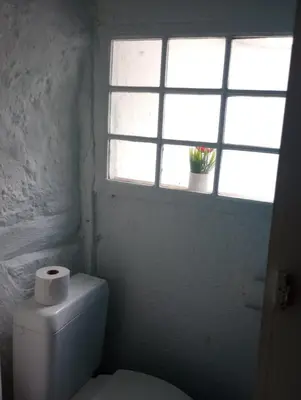 a bathroom with a toilet and a window with a roll of toilet paper at Logment saint denis in Liège