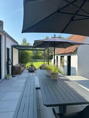 a picnic table with an umbrella on a patio at Vakantiehuis Zand7 in Lommel