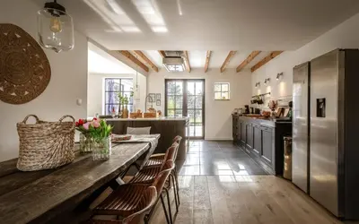 a kitchen with a wooden table and chairs at Vakantiehuis Zand7 in Lommel