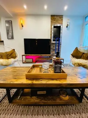 a coffee table in a living room with a tv at Superbe appartement chic et design in Seraing
