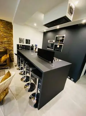 a bar with a row of stools in a kitchen at Superbe appartement chic et design in Seraing