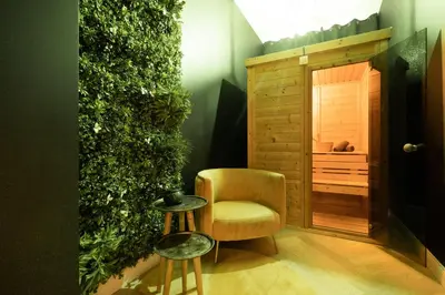 a room with a chair and a green wall at The 99, Appartement sauna & parking in Liège