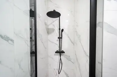 a shower with a shower head in a bathroom at The 99, Appartement sauna & parking in Liège