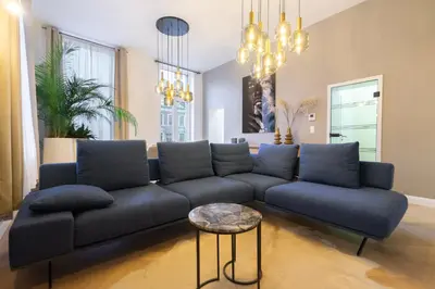 a living room with a blue couch and a table at The 99, Appartement sauna & parking in Liège