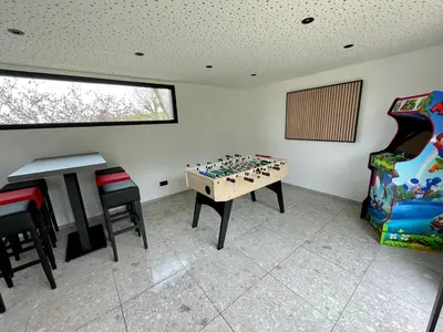 a room with a game table and chairs in it at Gite de Clermont in Thimister
