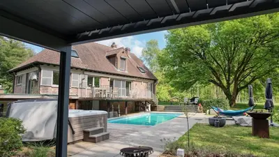 a backyard with a swimming pool and a house at Arthurs Palace in Heusden - Zolder