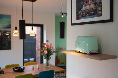a dining room with a table and a toaster on a shelf at unique hideaway, holiday house with large garden in Kortenaken