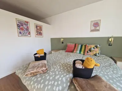 a bedroom with a bed and two baskets of towels at Parkvilla Vakantiehuis voor 23 personen in Heusden - Zolder