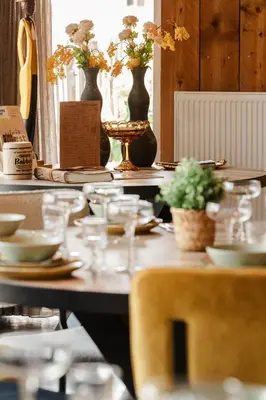 a table with plates and vases of flowers on it at Time - Out Genoelselderen in Riemst