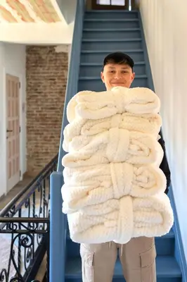 a man standing on stairs holding a large blanket at Time - Out Genoelselderen in Riemst