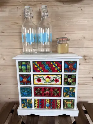 a cabinet with two glass bottles on top of it at Ontwaken tussen de paarden in Helen-Bos