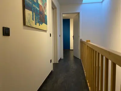 a hallway with a stairway with a painting on the wall at Casper House, Near Maastricht in Lanaken