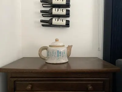 a tea pot sitting on a table next to a stack of wine bottles at Casper House, Near Maastricht in Lanaken